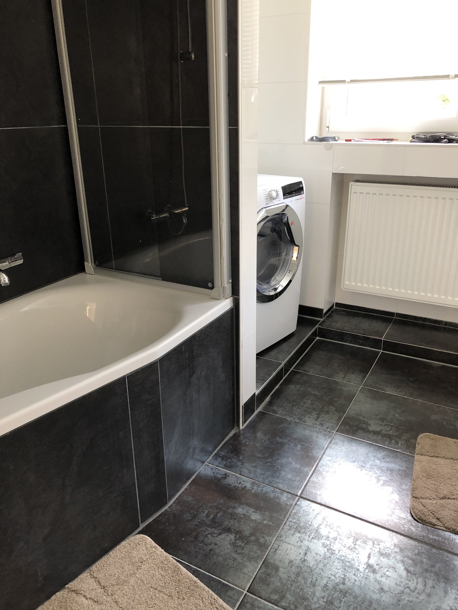 Badezimmer mit Badewanne und Waschmaschine